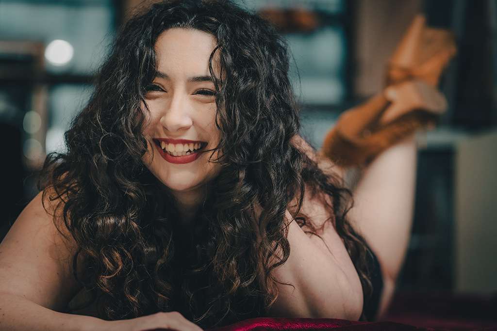 Boudoir photography in a studio setting with a relaxed moment between shots.